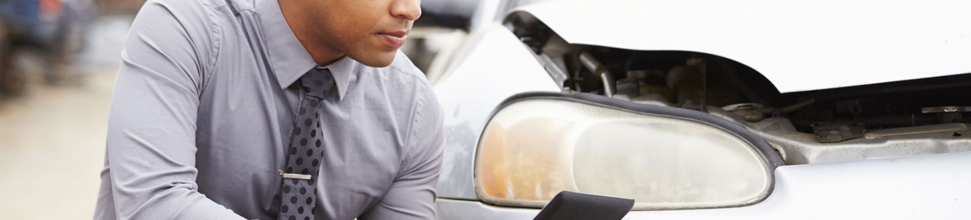 Worker inspects a damaged car