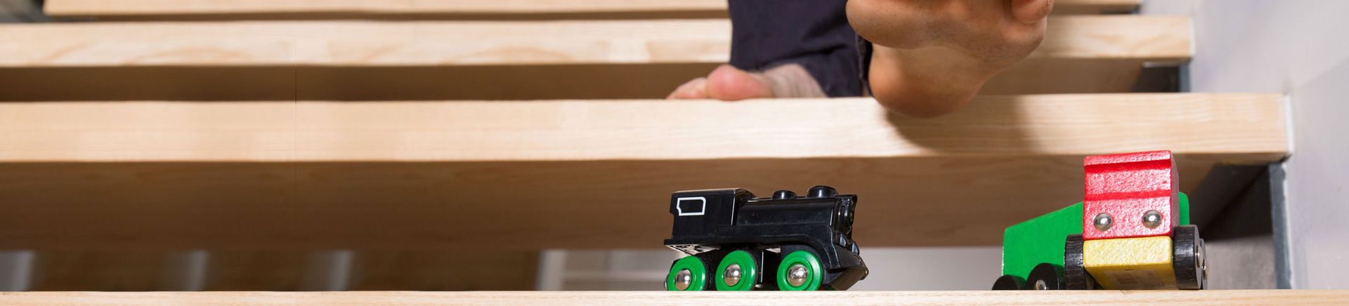 Person walks on stairs littered with toys